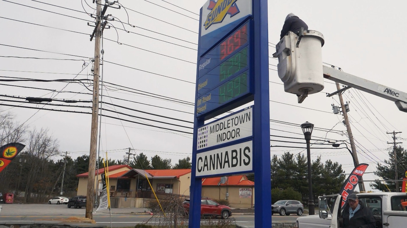 The Sunoco price sign on Route 211 with a Middletown Indoor Cannabis panel below the gas prices.